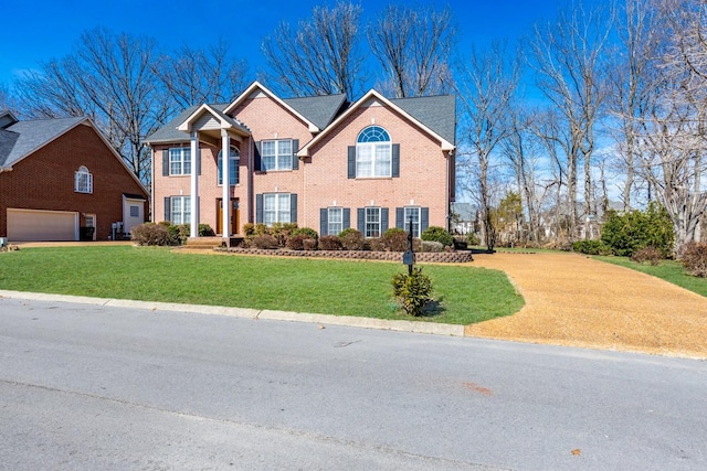 view of front of property featuring a garage, a front yard, and brick siding