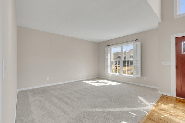 carpeted spare room featuring baseboards