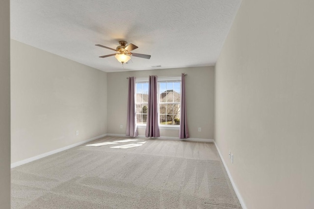 empty room featuring carpet floors, a textured ceiling, baseboards, and a ceiling fan