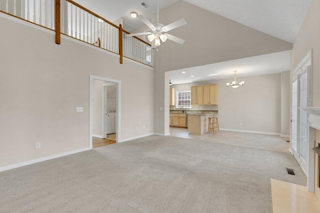 unfurnished living room with light colored carpet, a fireplace with flush hearth, a sink, baseboards, and visible vents