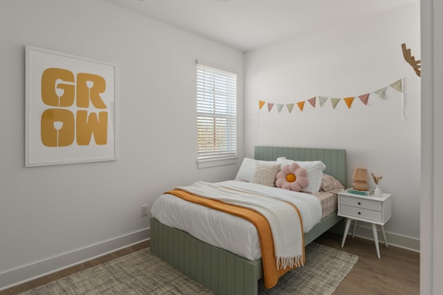 bedroom with baseboards and wood finished floors