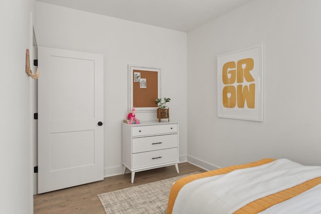 bedroom with wood finished floors and baseboards