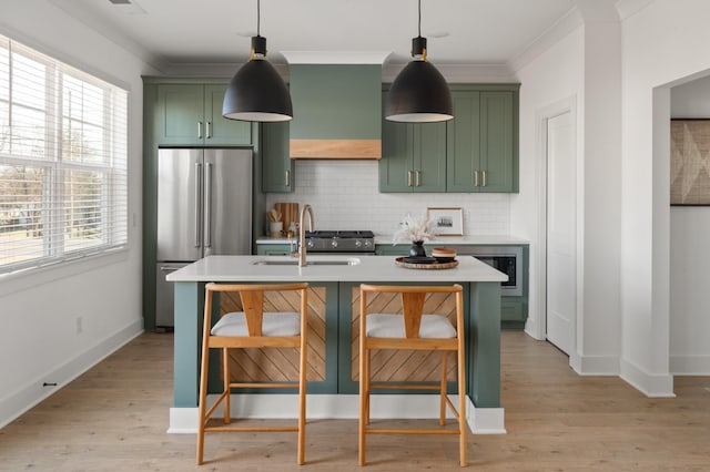 kitchen featuring high quality fridge, green cabinets, a sink, and light countertops