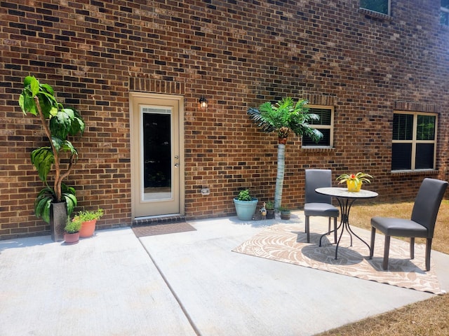 doorway to property with a patio area and brick siding