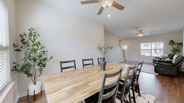 dining space featuring baseboards, stairway, ceiling fan, and wood finished floors