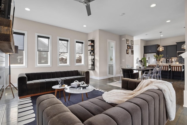 living area featuring baseboards, dark wood-type flooring, a ceiling fan, and recessed lighting