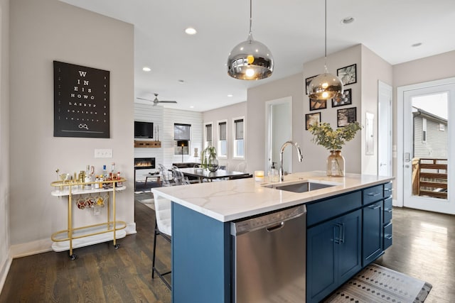 kitchen with blue cabinets, a fireplace, dark wood-style floors, a sink, and dishwasher