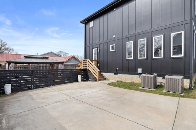 exterior space featuring central AC, crawl space, board and batten siding, and a patio area