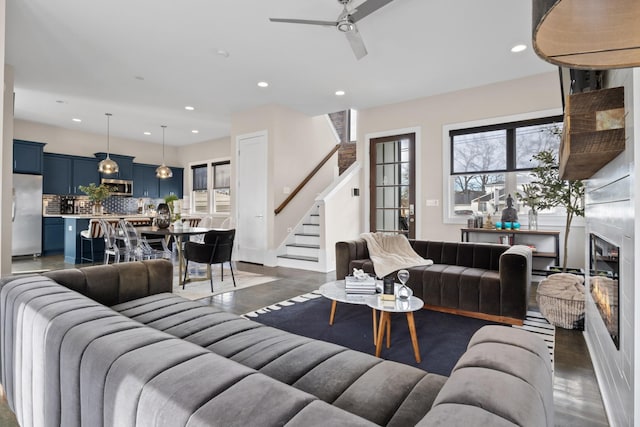 living room with stairway, a fireplace, finished concrete floors, and recessed lighting