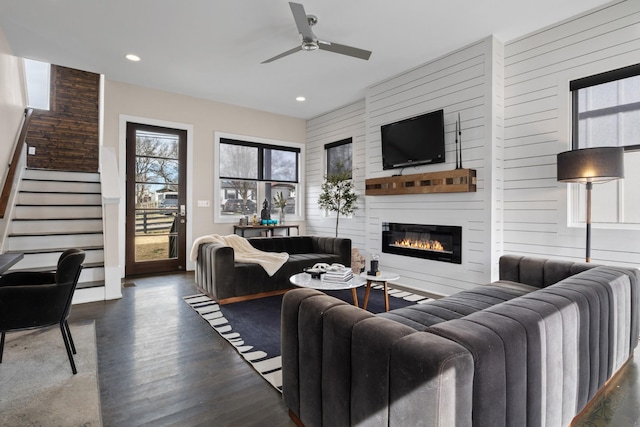 living room with recessed lighting, a large fireplace, wood finished floors, a ceiling fan, and stairs