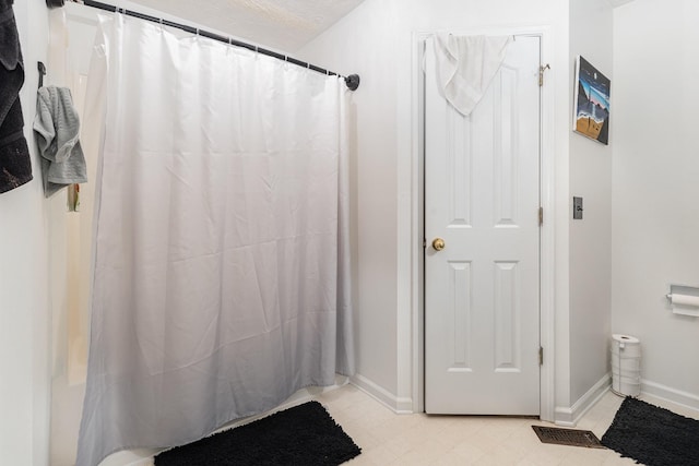 bathroom featuring curtained shower, visible vents, and baseboards