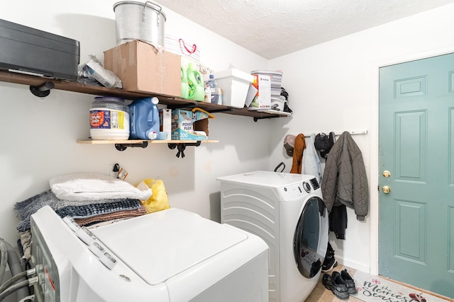 laundry area featuring laundry area, separate washer and dryer, and a textured ceiling