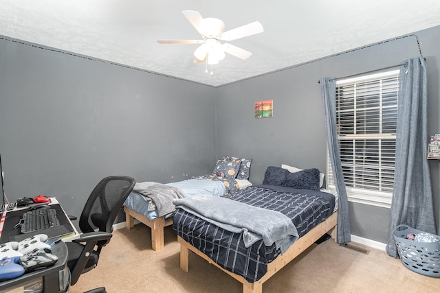 bedroom with baseboards, visible vents, carpet floors, and ceiling fan