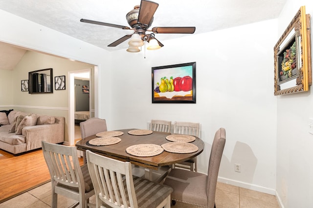 dining room featuring ceiling fan, light tile patterned flooring, baseboards, and a textured ceiling