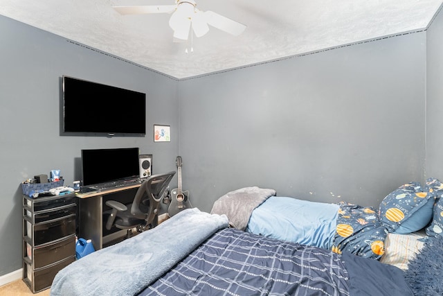 carpeted bedroom featuring a textured ceiling, baseboards, and a ceiling fan