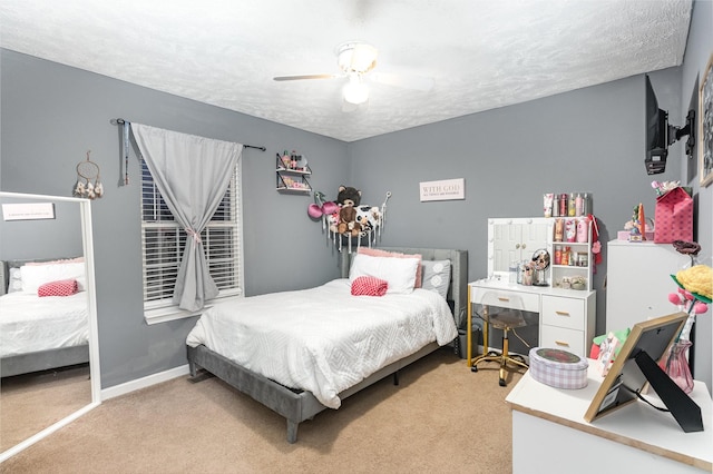 bedroom with a textured ceiling, ceiling fan, baseboards, and light carpet