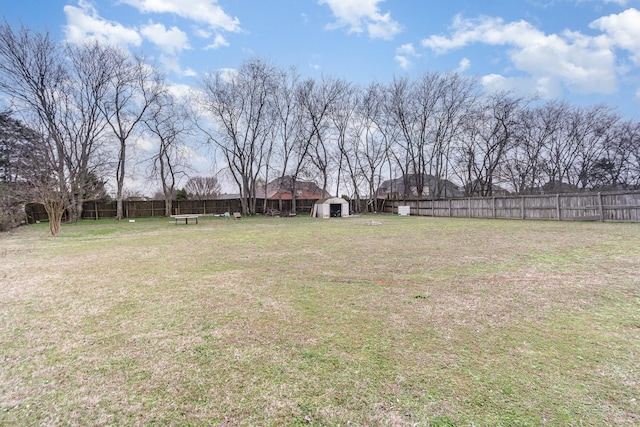 view of yard with an outdoor structure, fence, and a shed