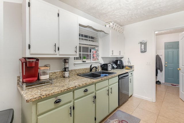 kitchen featuring baseboards, light tile patterned floors, dishwashing machine, a textured ceiling, and a sink