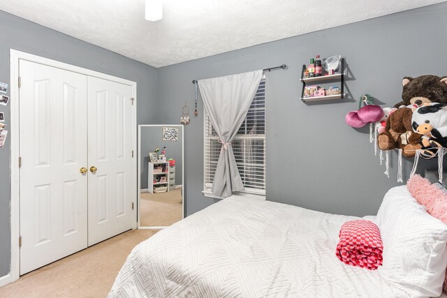 bedroom with a closet, a textured ceiling, and carpet