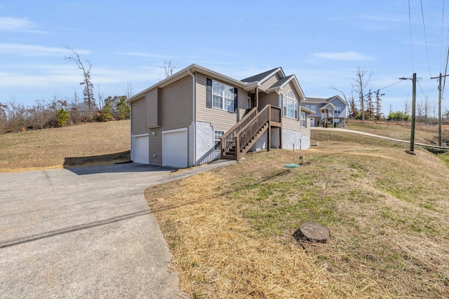 view of front facade with an attached garage, stairs, aphalt driveway, and a front yard