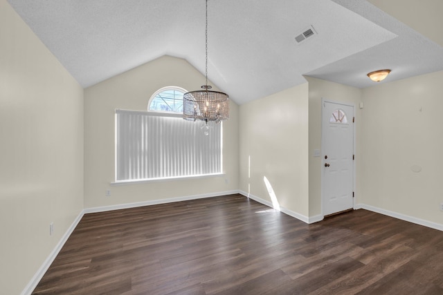 interior space with lofted ceiling, a textured ceiling, visible vents, and dark wood-style flooring