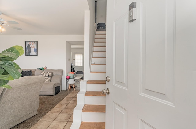 interior space featuring light tile patterned floors, ceiling fan, and stairway