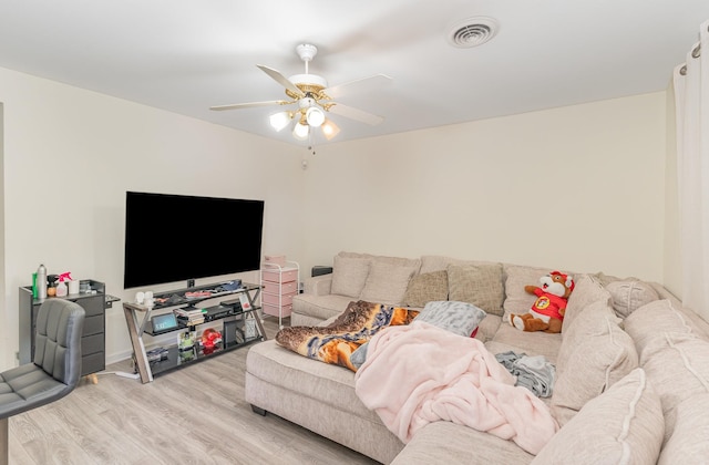 living area featuring light wood-style flooring, visible vents, and ceiling fan