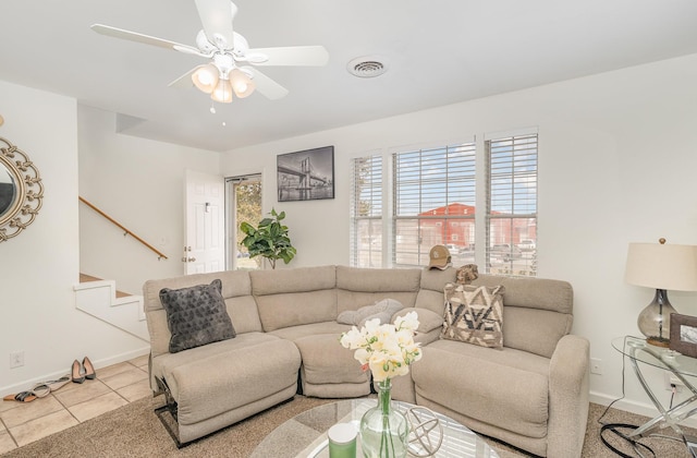 living area featuring visible vents, baseboards, ceiling fan, stairway, and tile patterned floors