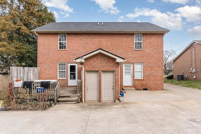 view of front of property featuring crawl space, fence, central AC unit, and brick siding