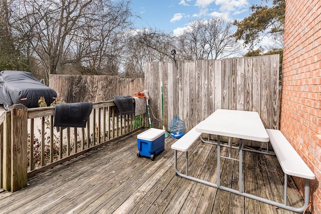 wooden terrace with a fenced backyard