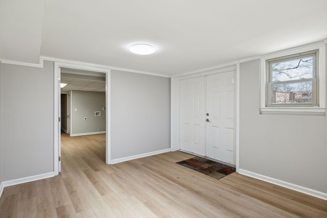 foyer entrance with light wood-style flooring and baseboards