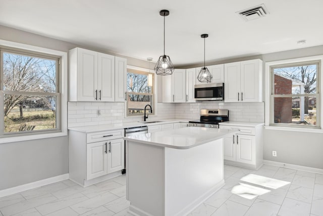 kitchen featuring stainless steel appliances, marble finish floor, visible vents, and baseboards