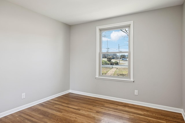 unfurnished room featuring baseboards and wood finished floors