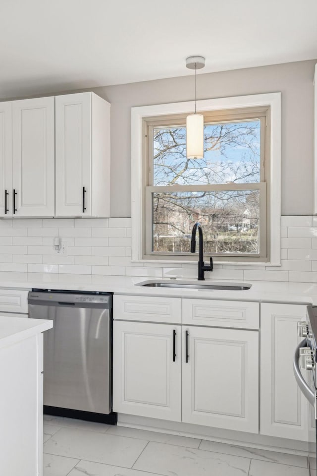 kitchen featuring marble finish floor, stainless steel appliances, a sink, and light countertops