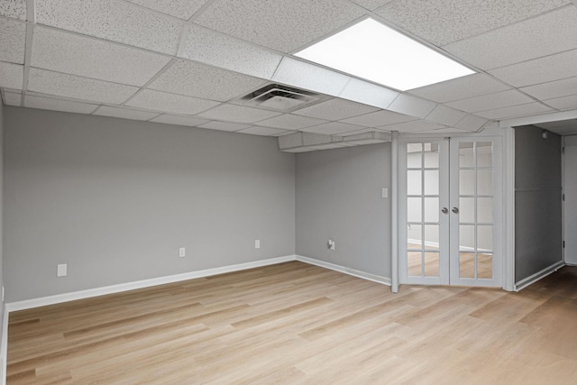 unfurnished room featuring a drop ceiling, wood finished floors, visible vents, and baseboards