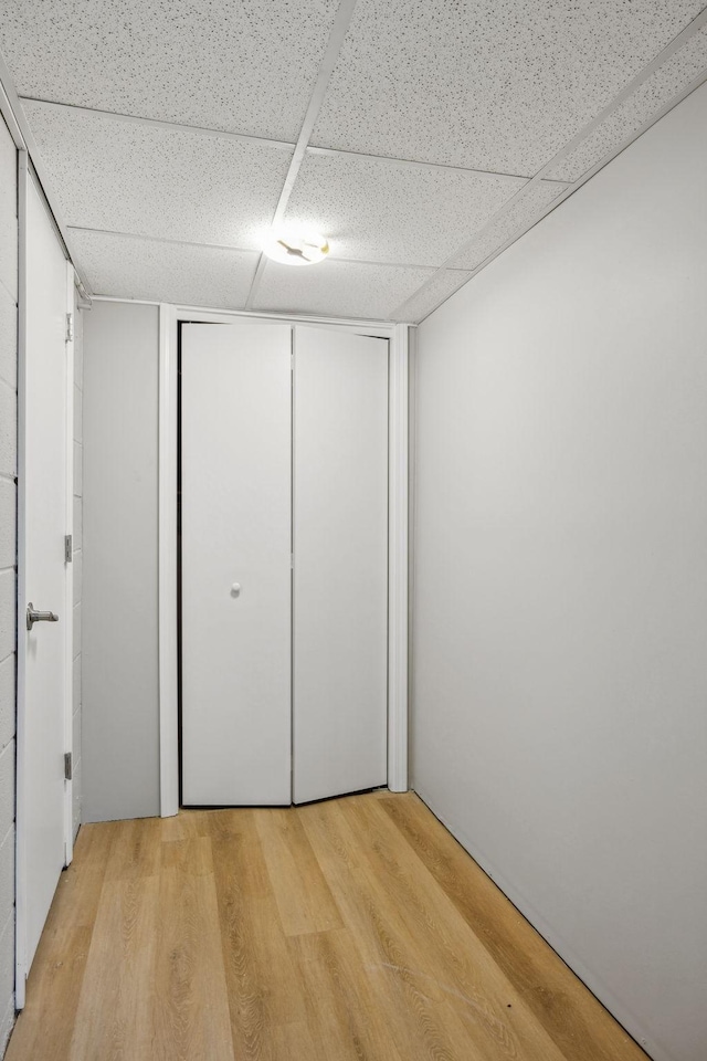 interior space featuring light wood finished floors and a paneled ceiling