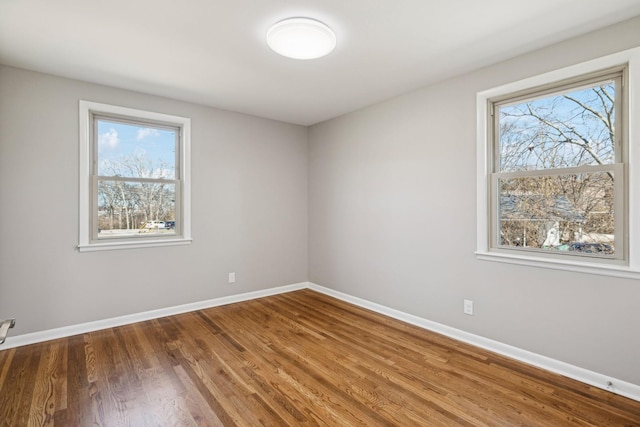 unfurnished room featuring baseboards and wood finished floors