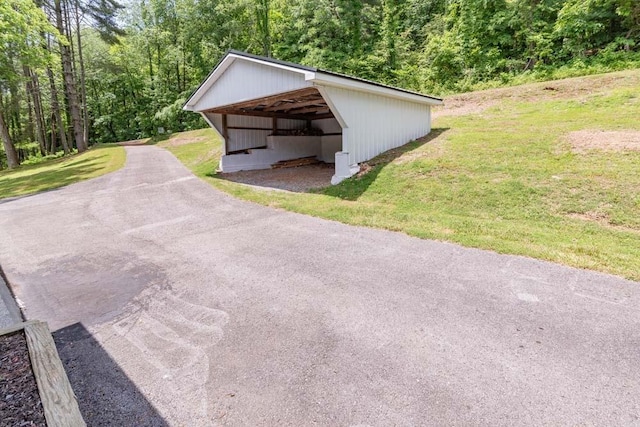 exterior space with a garage, an outdoor structure, a lawn, and an outbuilding