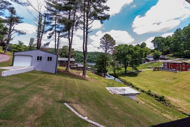 view of yard featuring a detached garage and an outbuilding