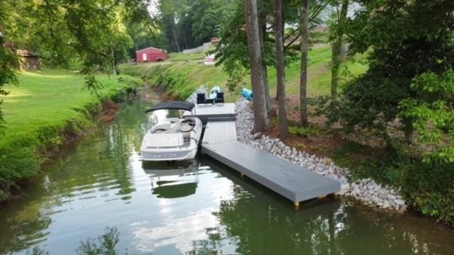 dock area with a yard and a water view