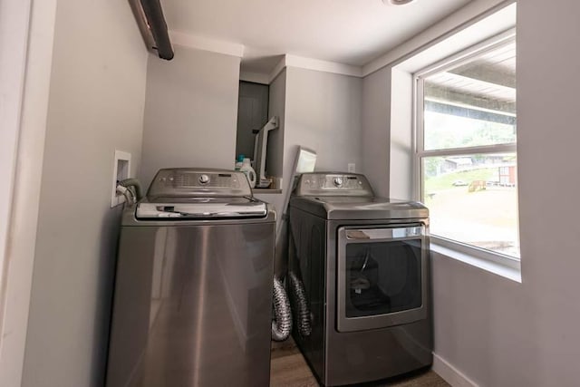 clothes washing area with laundry area, baseboards, and washer and dryer