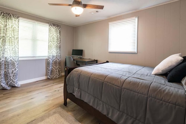 bedroom with baseboards, light wood-type flooring, visible vents, and a ceiling fan