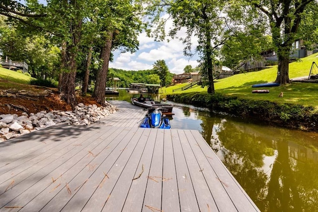 dock area featuring a water view and a yard