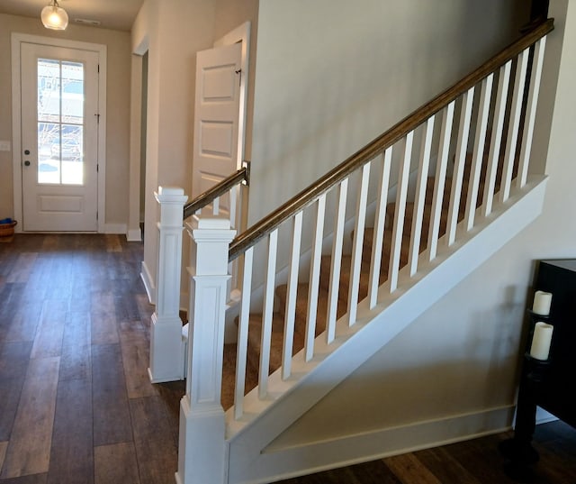 entryway featuring stairs, dark wood-type flooring, and baseboards