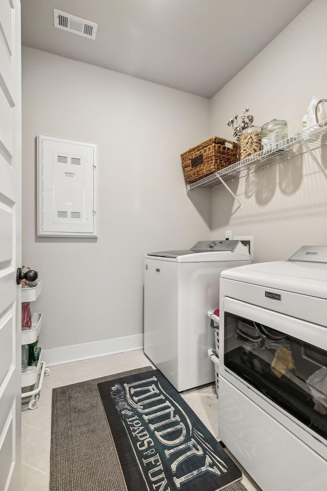 laundry room with light tile patterned floors, visible vents, separate washer and dryer, laundry area, and baseboards