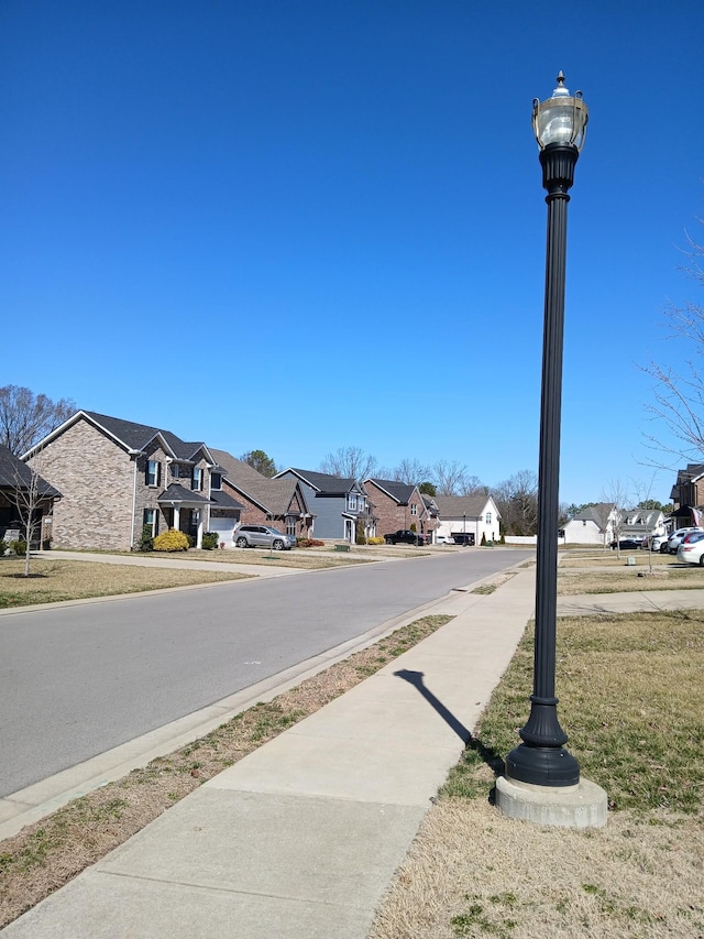 view of street featuring sidewalks, street lighting, and a residential view