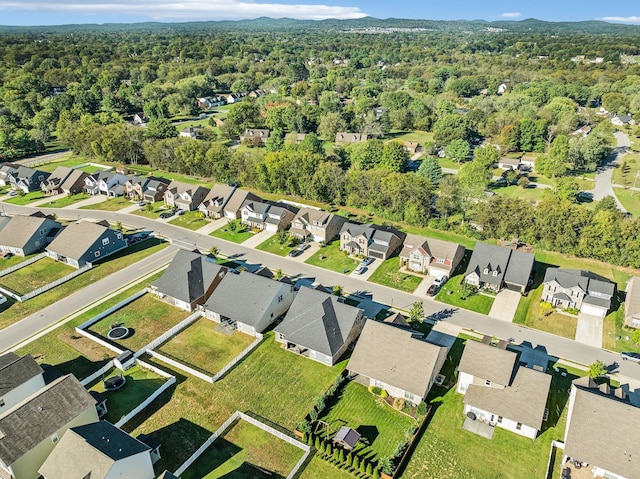 drone / aerial view featuring a residential view and a wooded view