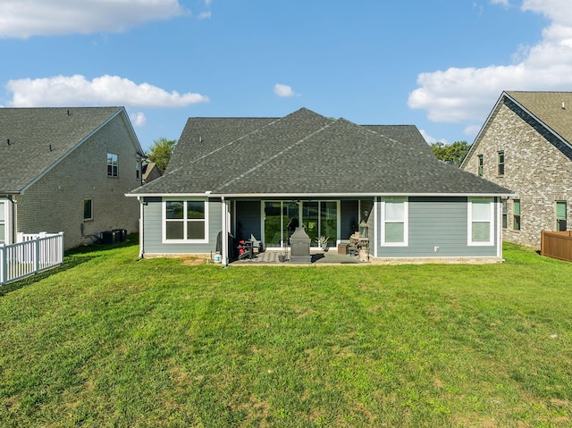 back of property featuring a patio area, a yard, fence, and roof with shingles