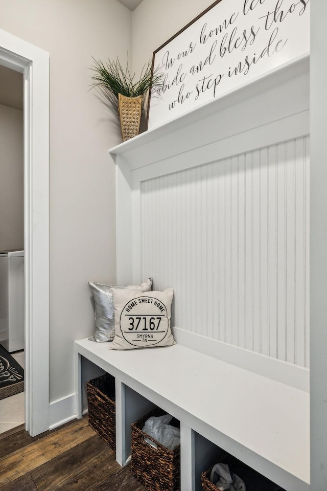 mudroom with dark wood finished floors and baseboards