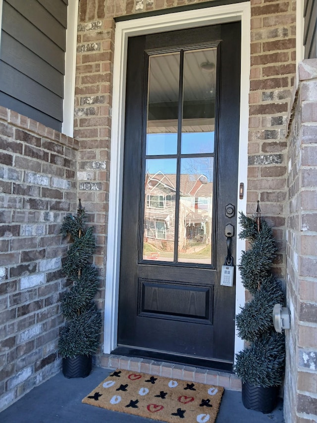 property entrance featuring brick siding